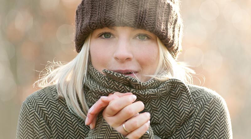 Frierende Frau mit warmer Winterkleidung